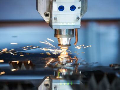 Laser cutting machine in action with sparks on a metallic surface